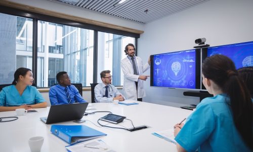 Doctor giving presentation to team of interim doctors at conference room