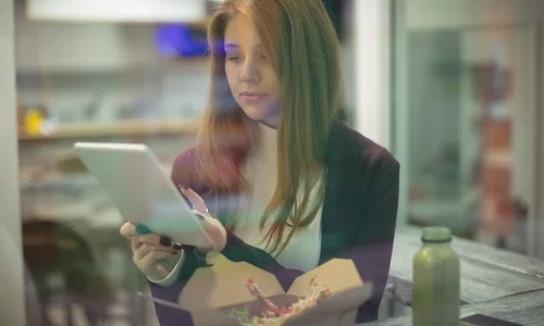 woman-using-digital-tablet-while-eating-salad-scaled-1.webp
